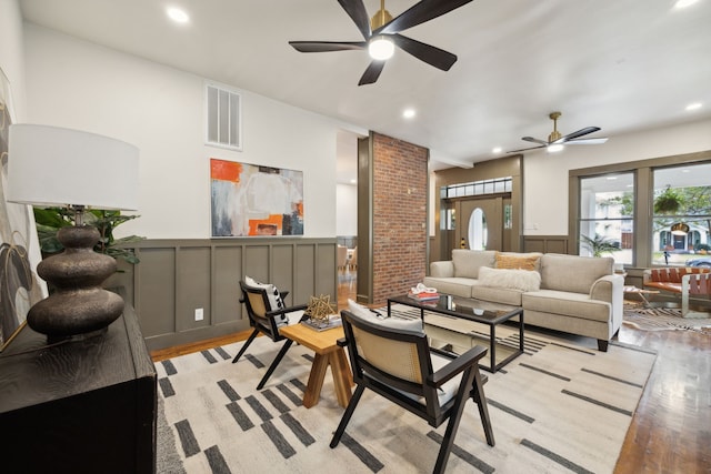 living room with light hardwood / wood-style flooring and ceiling fan