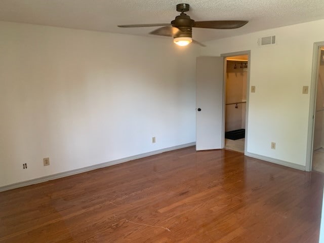 unfurnished room featuring a textured ceiling, wood-type flooring, and ceiling fan