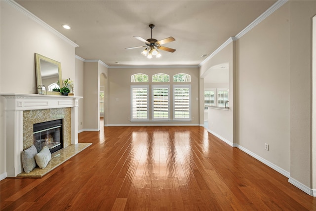 unfurnished living room featuring crown molding, ceiling fan, hardwood / wood-style floors, and a high end fireplace