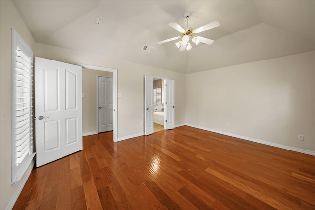 unfurnished bedroom with ensuite bathroom, wood-type flooring, ceiling fan, and vaulted ceiling