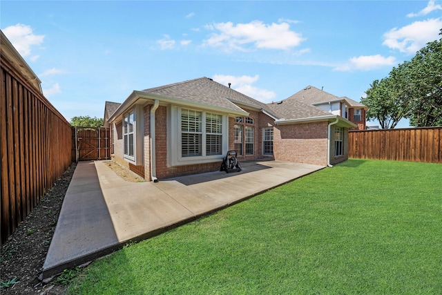 rear view of house featuring a patio area and a lawn