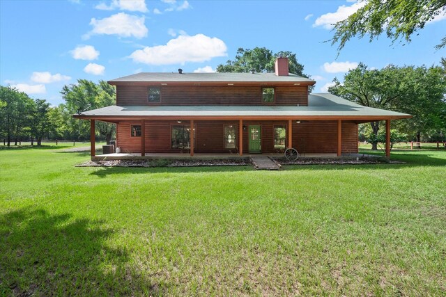 rear view of property featuring a lawn and a patio