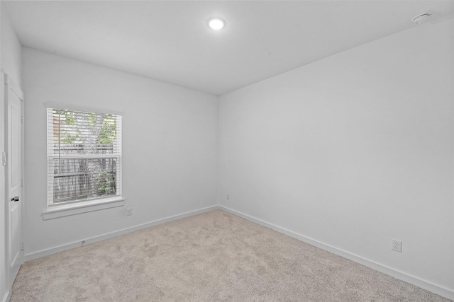 unfurnished room featuring light carpet