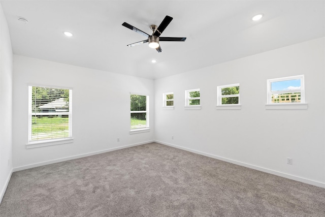 carpeted empty room featuring ceiling fan and a wealth of natural light