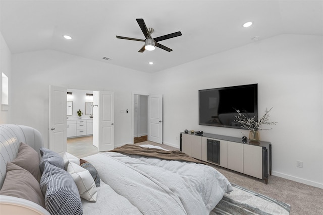 carpeted bedroom with ensuite bath, ceiling fan, and vaulted ceiling