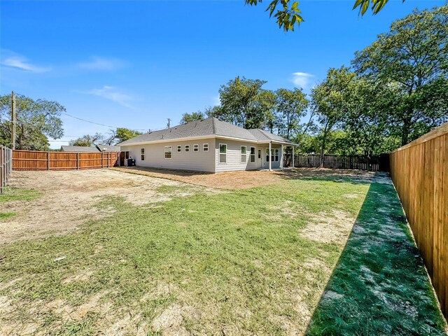 rear view of property featuring a yard