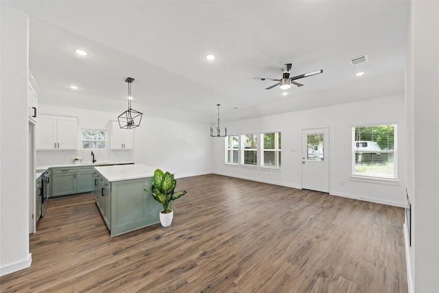 kitchen with decorative light fixtures, hardwood / wood-style flooring, a kitchen island, and a wealth of natural light