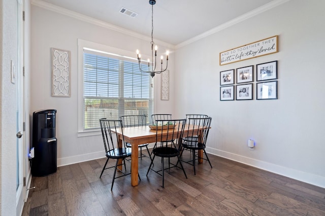 dining area with dark wood-type flooring, ornamental molding, and a chandelier