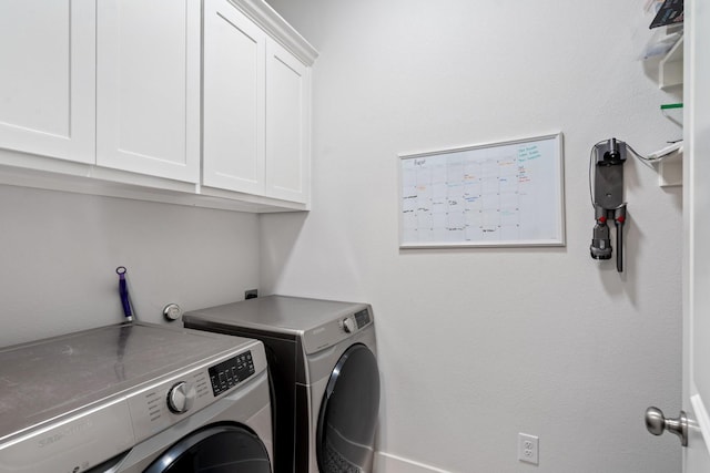 laundry room with separate washer and dryer and cabinets