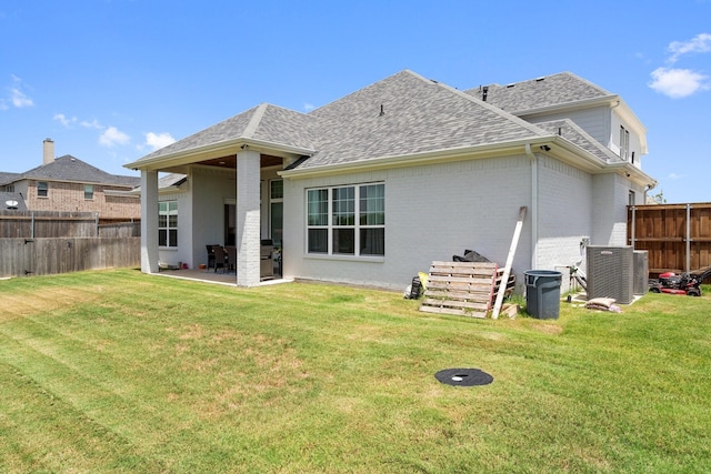 back of property featuring central AC unit, a patio area, and a lawn