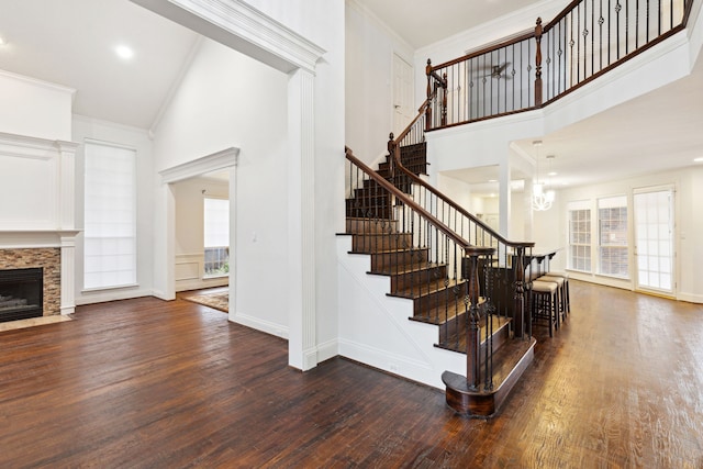 stairway featuring wood-type flooring, high vaulted ceiling, and crown molding