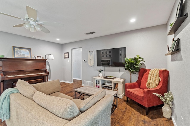 living room featuring dark wood-type flooring and ceiling fan