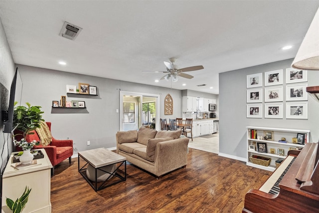 living room featuring wood-type flooring, sink, and ceiling fan