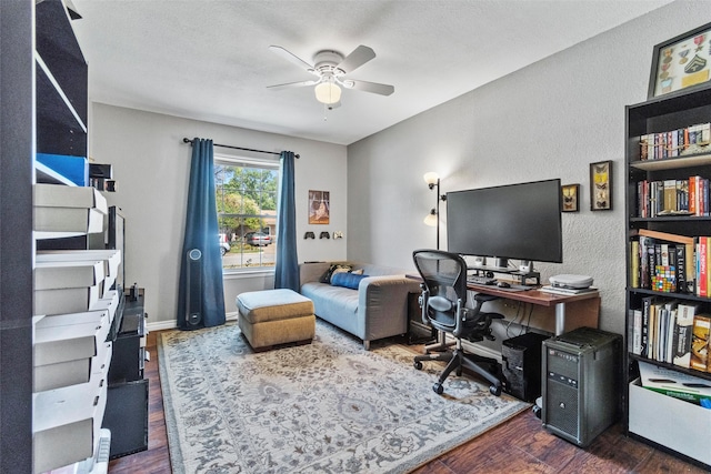 office featuring dark hardwood / wood-style floors, ceiling fan, and a textured ceiling