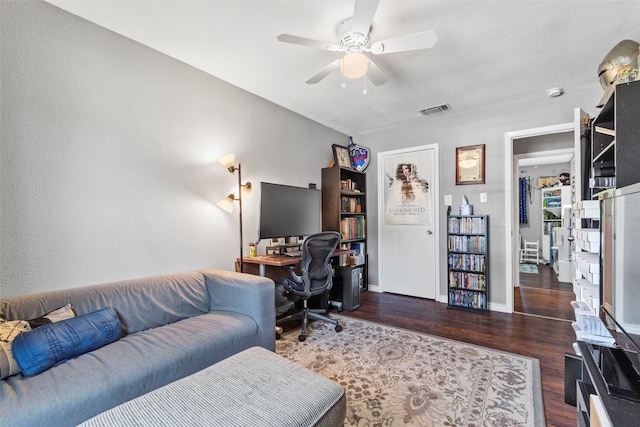 home office with ceiling fan and dark hardwood / wood-style flooring