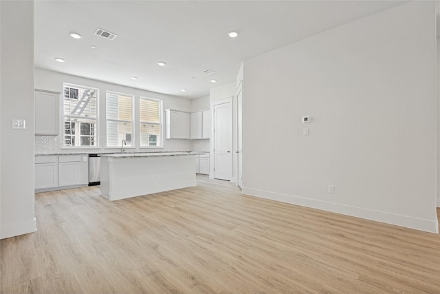 unfurnished living room with a sink, visible vents, recessed lighting, and light wood-style floors