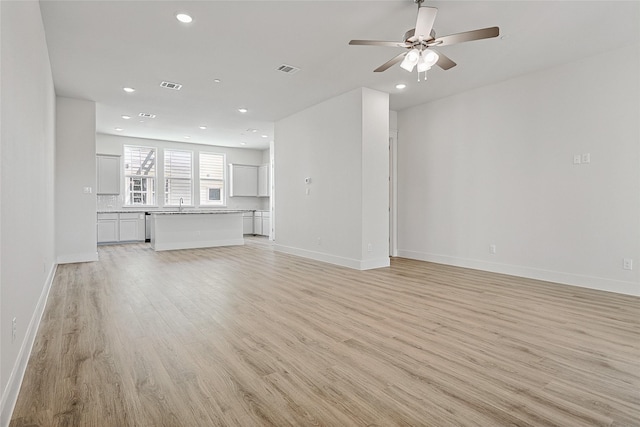 unfurnished living room with recessed lighting, light wood-style floors, a ceiling fan, visible vents, and baseboards