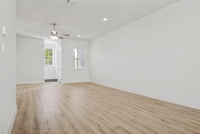 spare room featuring visible vents, ceiling fan, light wood-style flooring, and baseboards