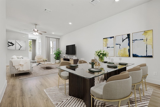 dining area featuring a ceiling fan, visible vents, baseboards, and light wood-type flooring