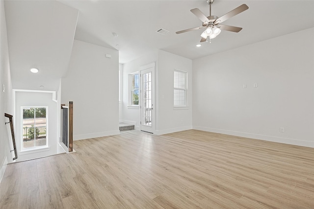 unfurnished living room featuring light wood-type flooring, visible vents, a wealth of natural light, and ceiling fan