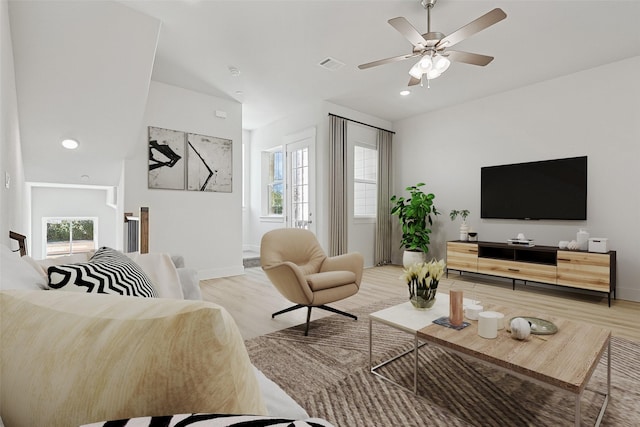 living area featuring visible vents, ceiling fan, baseboards, and light wood-style floors