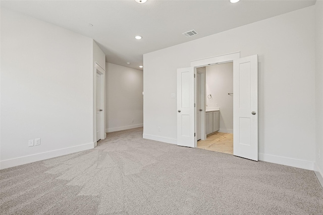 unfurnished bedroom featuring baseboards, visible vents, light carpet, and recessed lighting