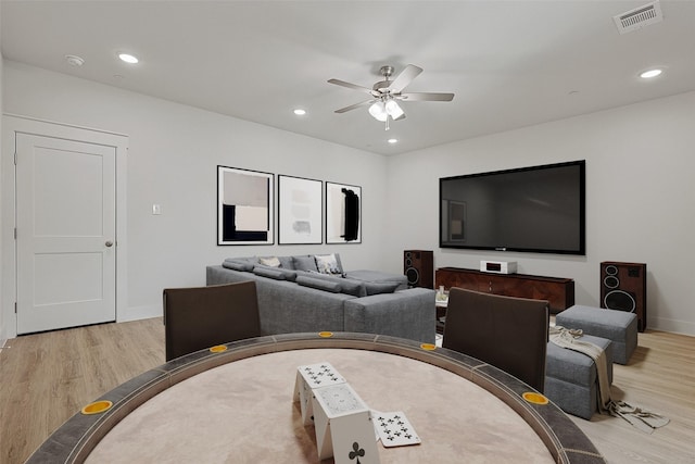 living room with baseboards, visible vents, ceiling fan, and light wood-style floors
