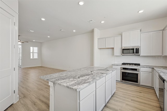 kitchen featuring tasteful backsplash, appliances with stainless steel finishes, and light wood-style flooring