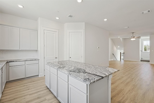 kitchen with visible vents, a center island, light wood-style flooring, and recessed lighting