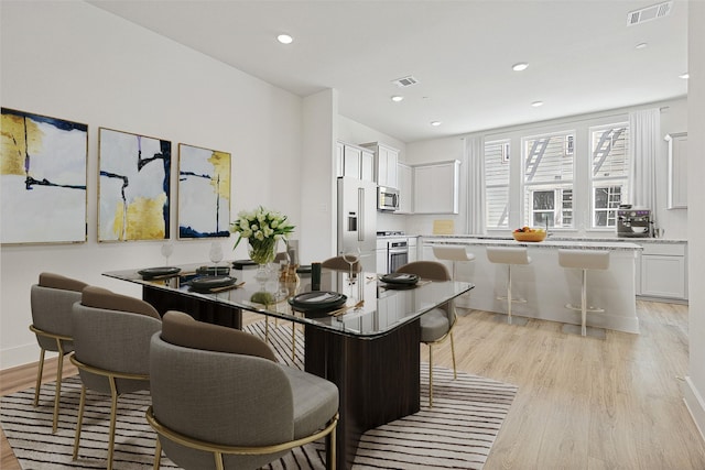 dining room featuring visible vents, light wood-type flooring, and recessed lighting