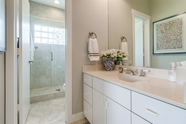 bathroom with vanity, a shower with shower door, and toilet