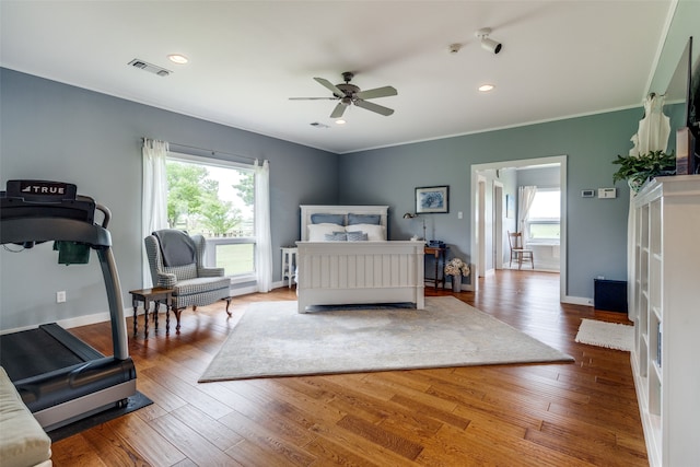 bedroom with crown molding, ceiling fan, and wood-type flooring