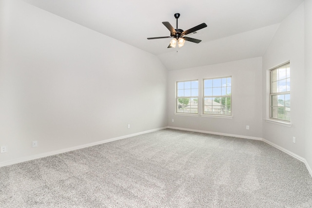 unfurnished room featuring vaulted ceiling, carpet, a healthy amount of sunlight, and ceiling fan