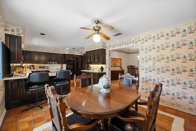 dining space with ceiling fan and ornamental molding