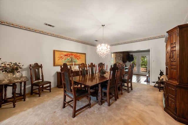 carpeted dining area featuring french doors, a notable chandelier, and ornamental molding