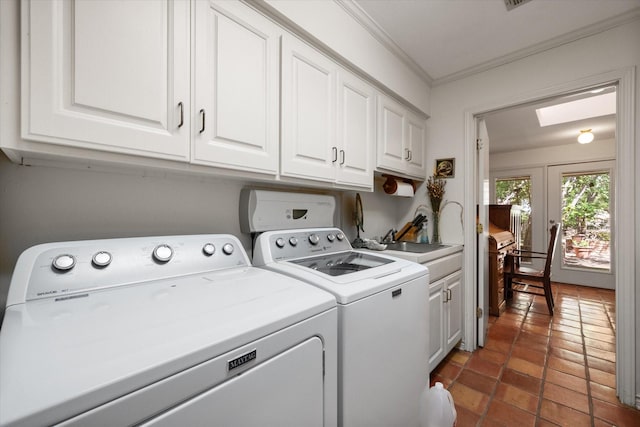 clothes washing area featuring a skylight, cabinets, independent washer and dryer, crown molding, and dark tile patterned flooring