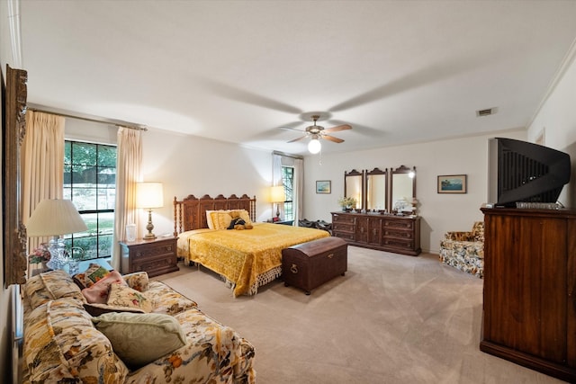 carpeted bedroom with ceiling fan and crown molding