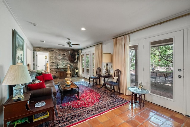 tiled living room featuring ceiling fan, french doors, brick wall, and ornamental molding