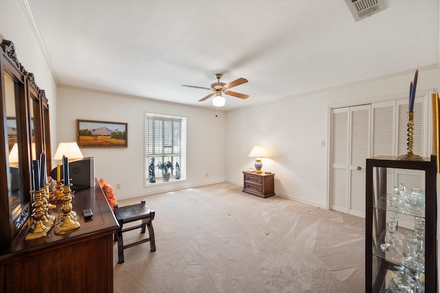 home office featuring light carpet, ceiling fan, and crown molding