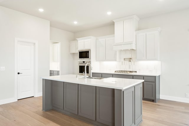 2302 Prosper Way, Mansfield, TX 76063 - kitchen with light countertops, gray cabinets, stainless steel appliances, a sink, and light wood-style floors