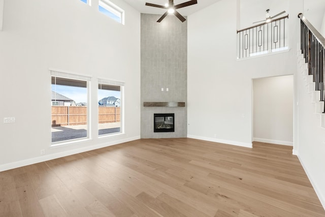 2302 Prosper Way, Mansfield, TX 76063 - unfurnished living room featuring a ceiling fan, a tile fireplace, baseboards, and light wood finished floors