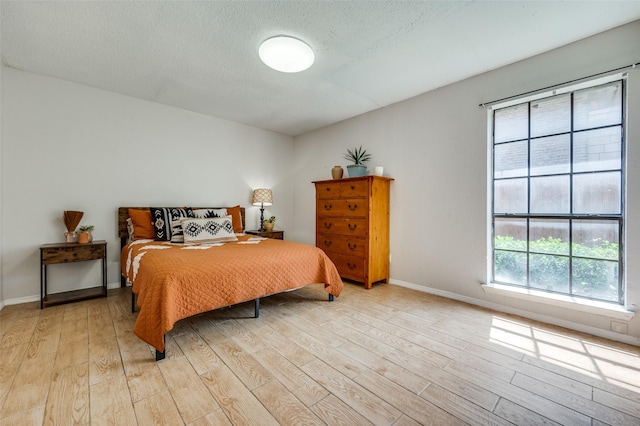 bedroom featuring a textured ceiling and light wood-type flooring