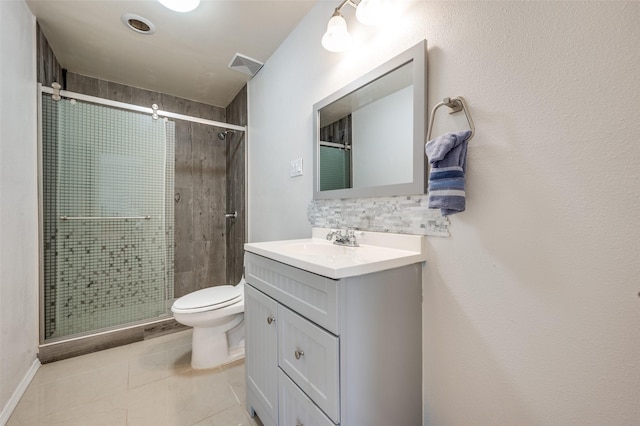 bathroom featuring vanity, toilet, tile patterned flooring, and a shower with door