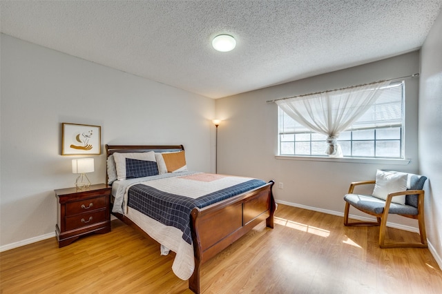 bedroom featuring a textured ceiling and light wood-type flooring