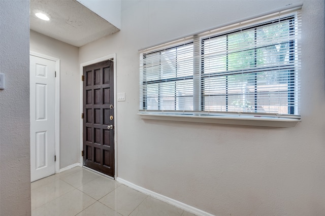 tiled entrance foyer featuring a healthy amount of sunlight