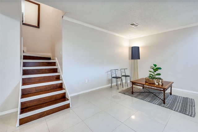 stairway featuring tile patterned floors, ornamental molding, and a textured ceiling