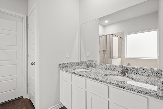 bathroom with hardwood / wood-style floors, an enclosed shower, and vanity