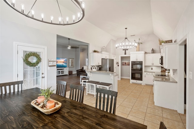 dining room with high vaulted ceiling and light tile patterned flooring