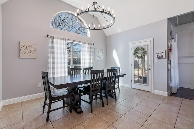 tiled dining room featuring a towering ceiling and an inviting chandelier