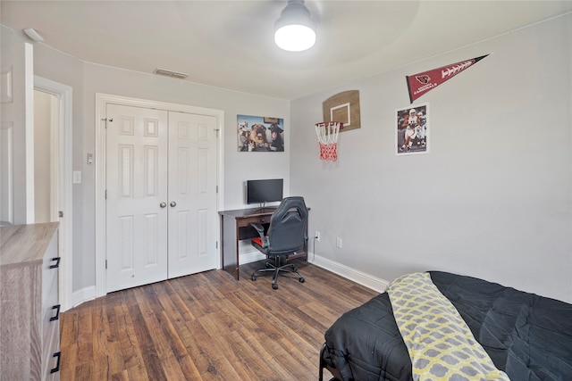 bedroom with dark hardwood / wood-style floors, a closet, and ceiling fan